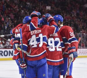 Un trio des Canadiens se félicitant d'un but sur la glace.