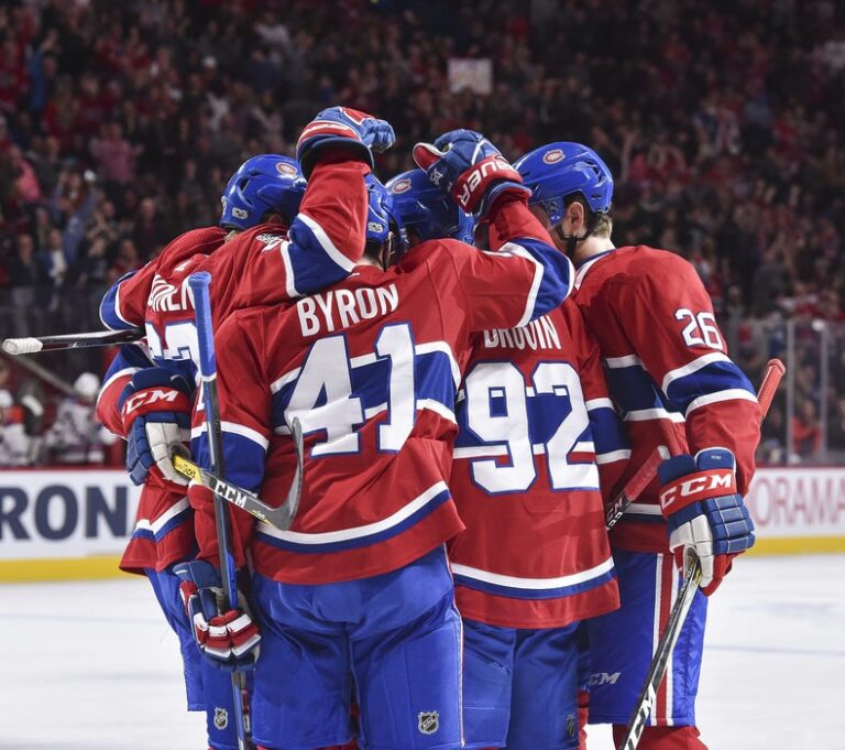 Un trio des Canadiens se félicitant d'un but sur la glace.